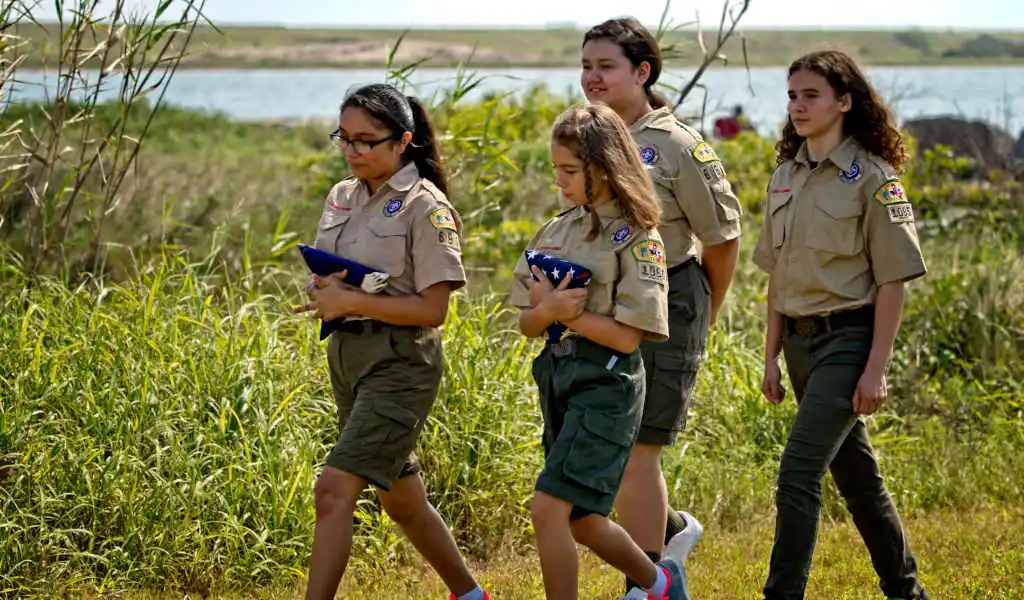 Scouts BSA girls carrying flag